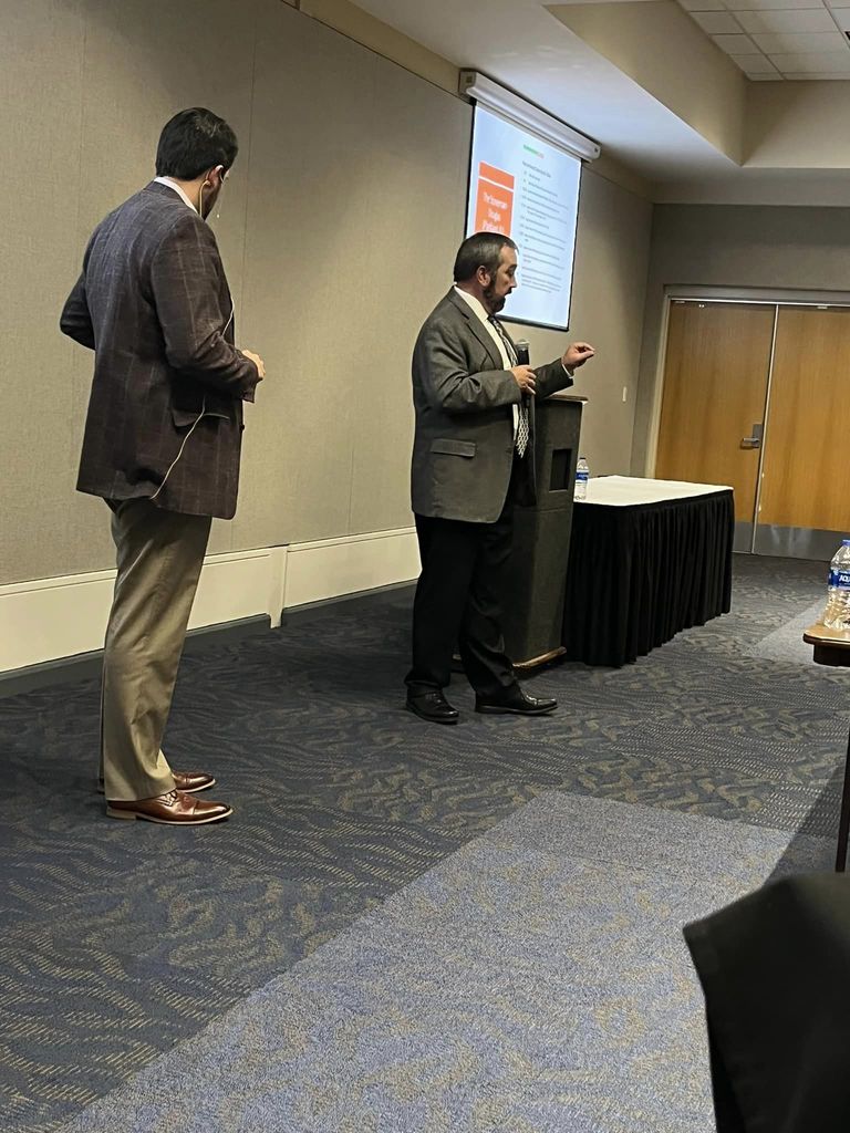 two speakers in the front of a conference room