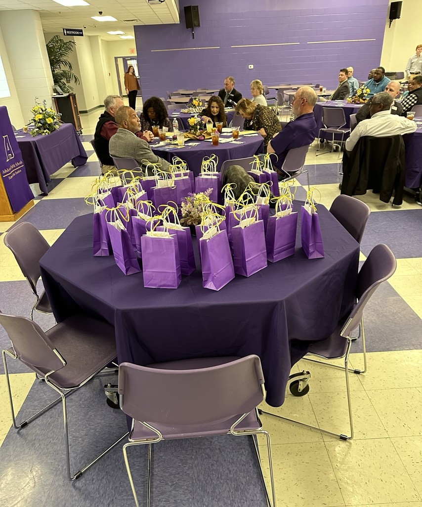 Attendees and table with purple gift bags